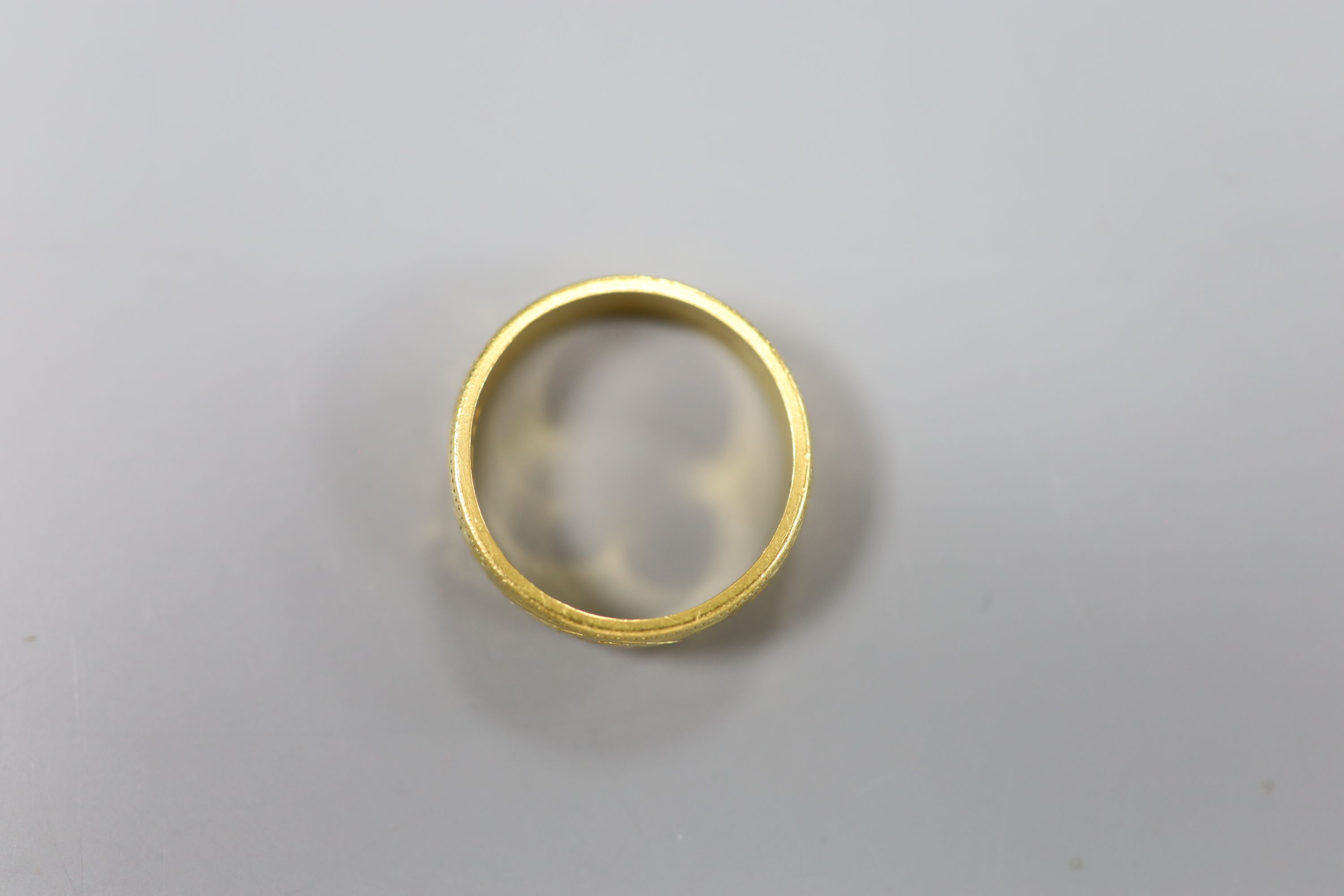 A 22ct engraved gold wedding band, 7.6g.